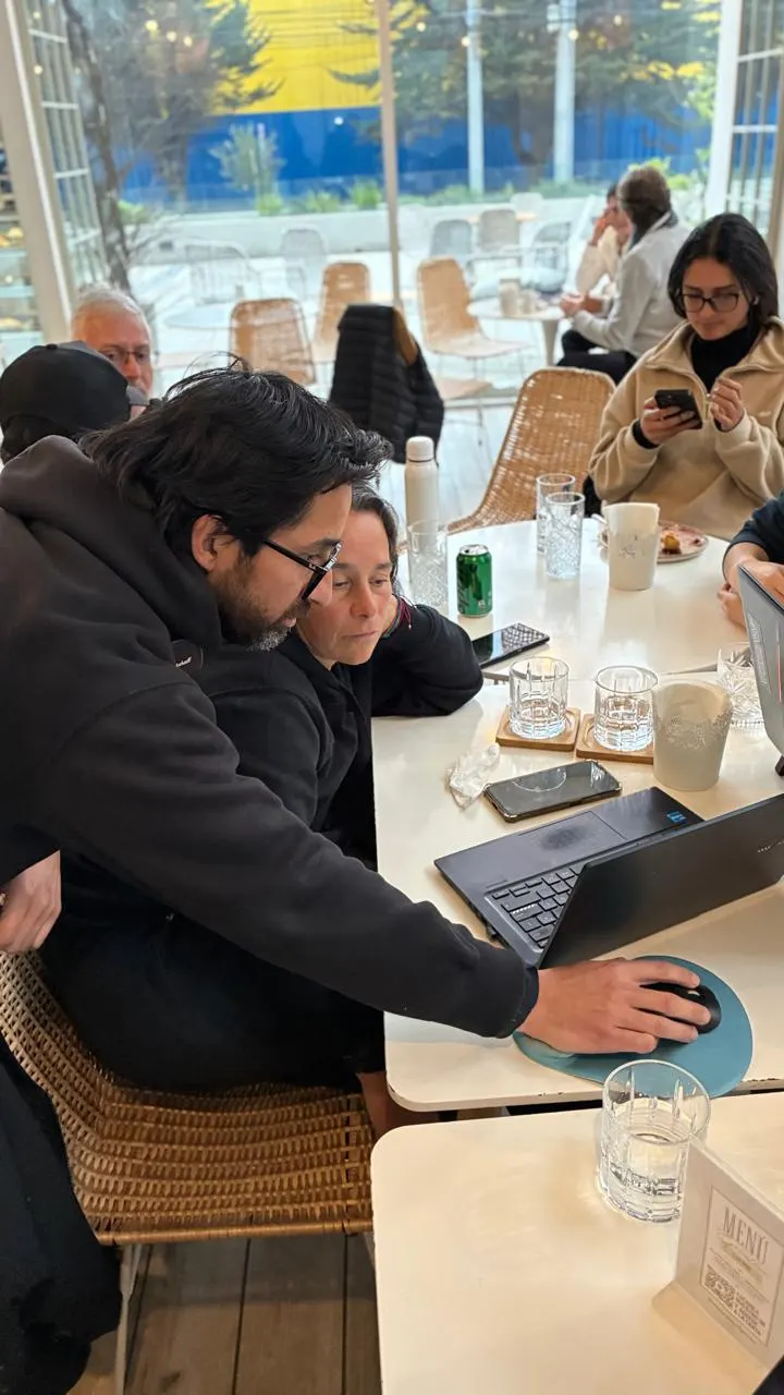 Dos asistentes haciendo pair-building con Lovable en sus laptops durante el coworking en Concón