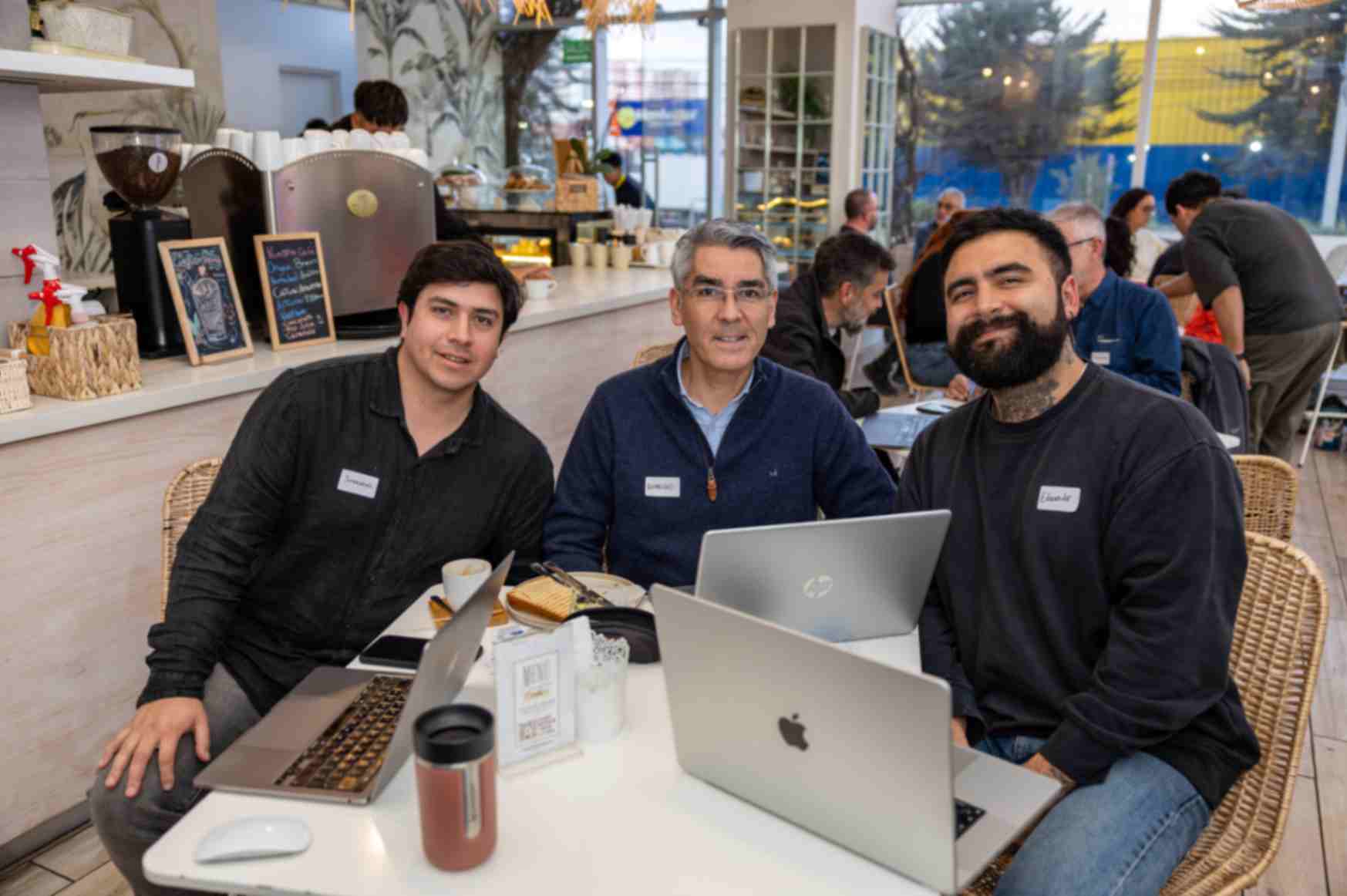 Sebastián Gutiérrez, Rodrigo Díaz y Eduardo López trabajando con sus laptops en el Founder Series x Lovable en Philia Casa de Café, Concón